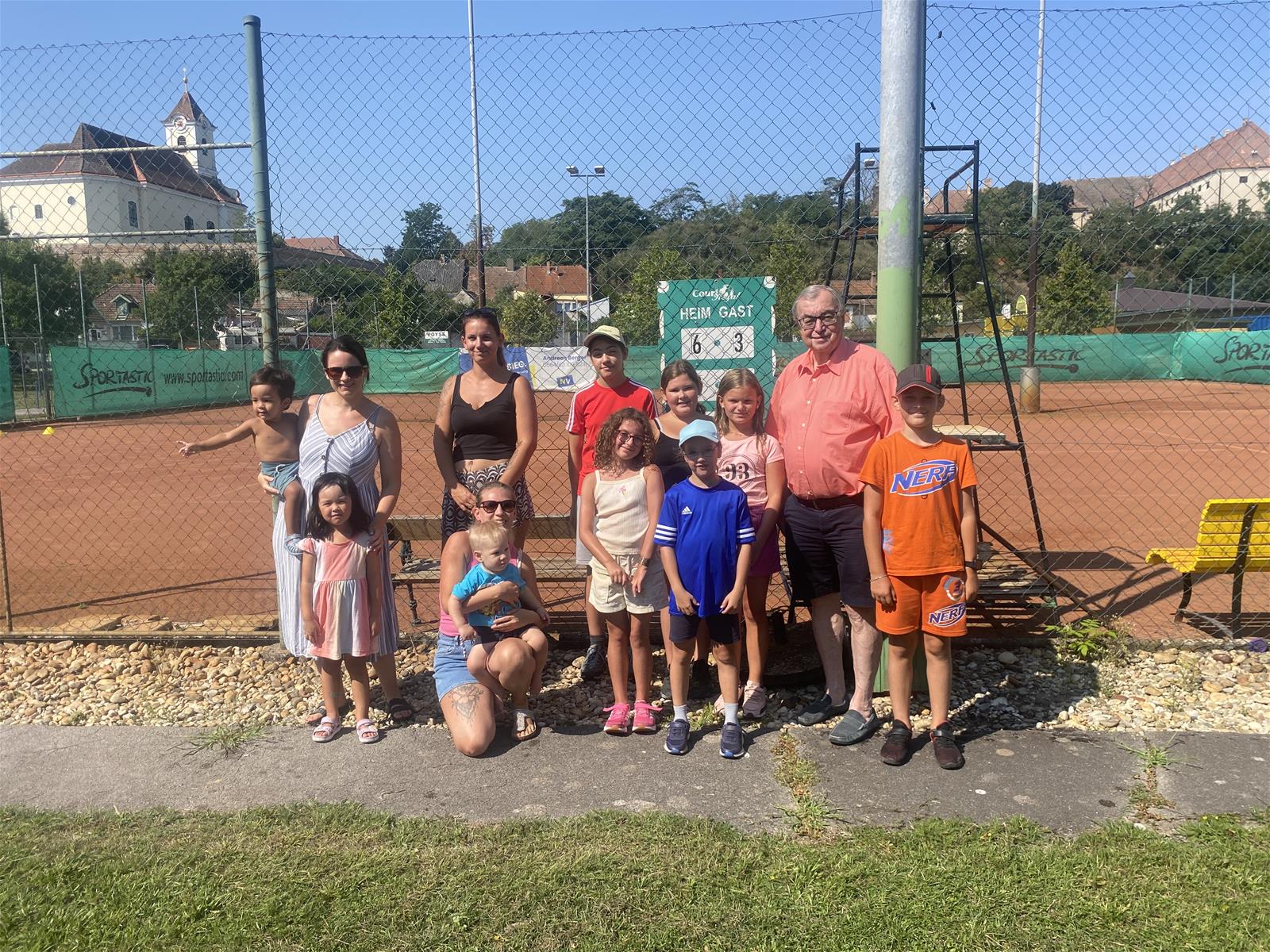 Foto: Bürgermeister Wolfram Erasim mit Spielleiterin Jessica Nemecek und Kindern beim Ferienspiel des Tennisvereins.
